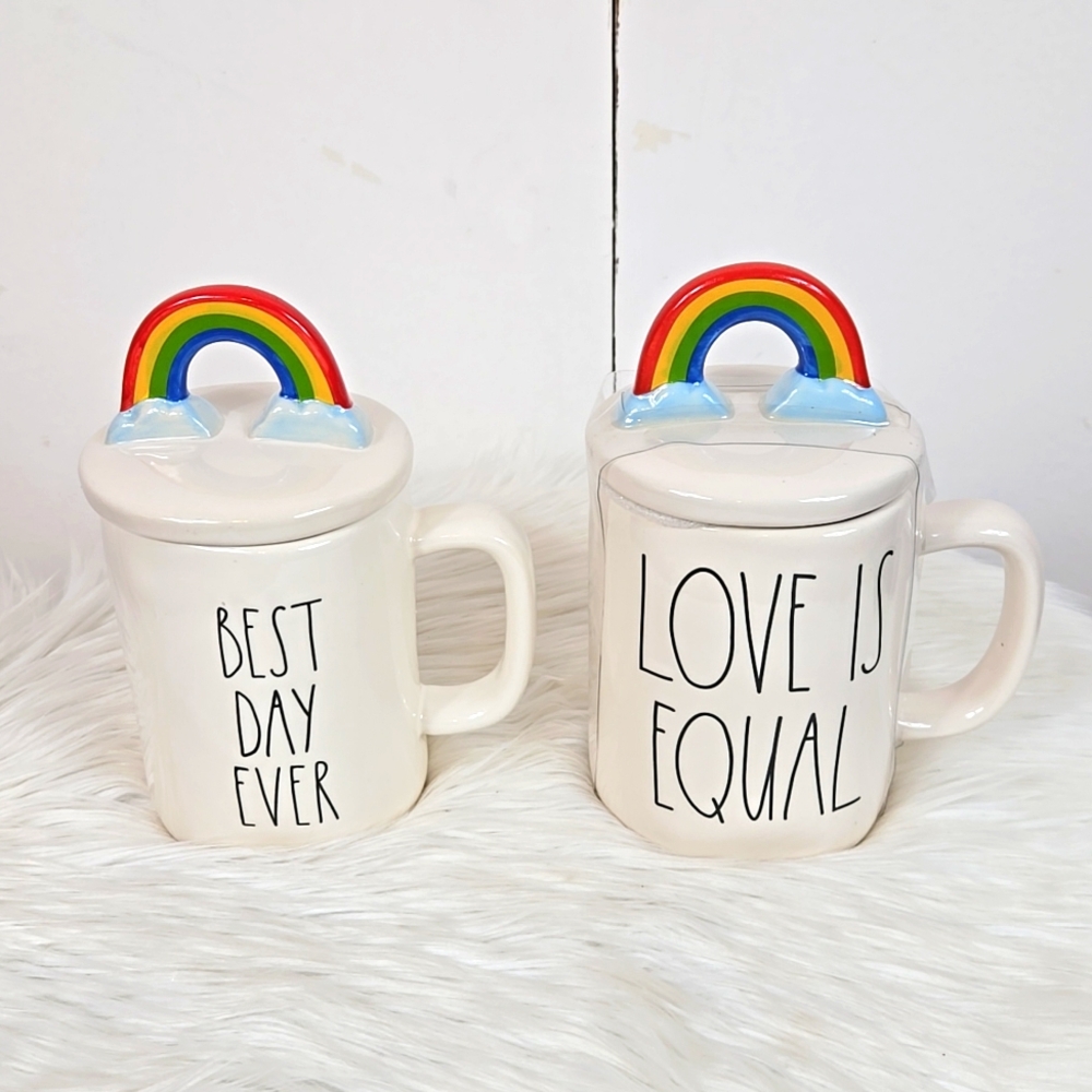Rae Dunn coffee mugs with rainbow lids.